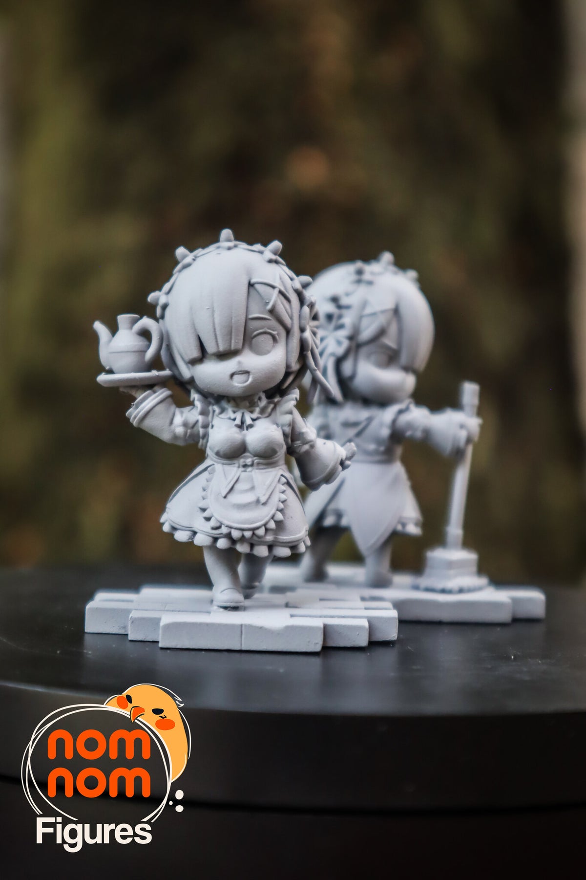 Sculptor's photo of an unpainted print: both figures from the front, the tray-carrying twin in focus