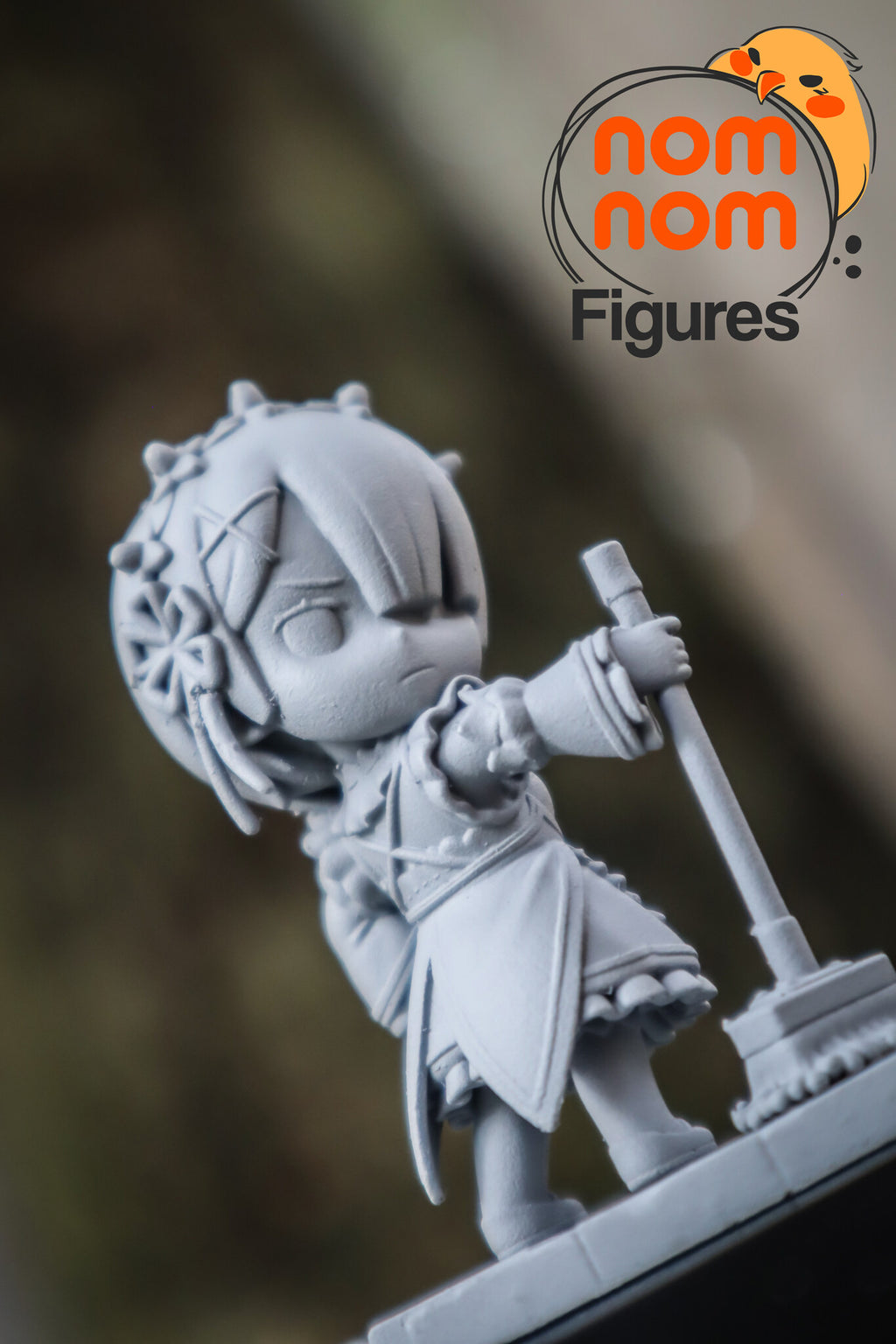 Sculptor's photo of an unpainted print: close view of the mop-holding twin's face and headdress