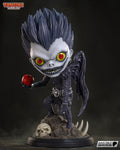 Sculptor's render of the painted design (kit ships unpainted): front view of the chibi winged reaper with spiked hair and a wide grin, holding out a red apple on the rock pile base