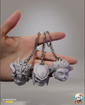 Sculptor's render of the painted design (kit ships unpainted, hardware not included): a hand holding the three-horned headband fighter, the masked hunter and the scarred spiky crown on key rings