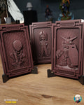 Sculptor's render (kit ships unpainted): the web-masked hero, the scarf-wearing young man and the mecha robot plaques standing in black display stands on a wooden table