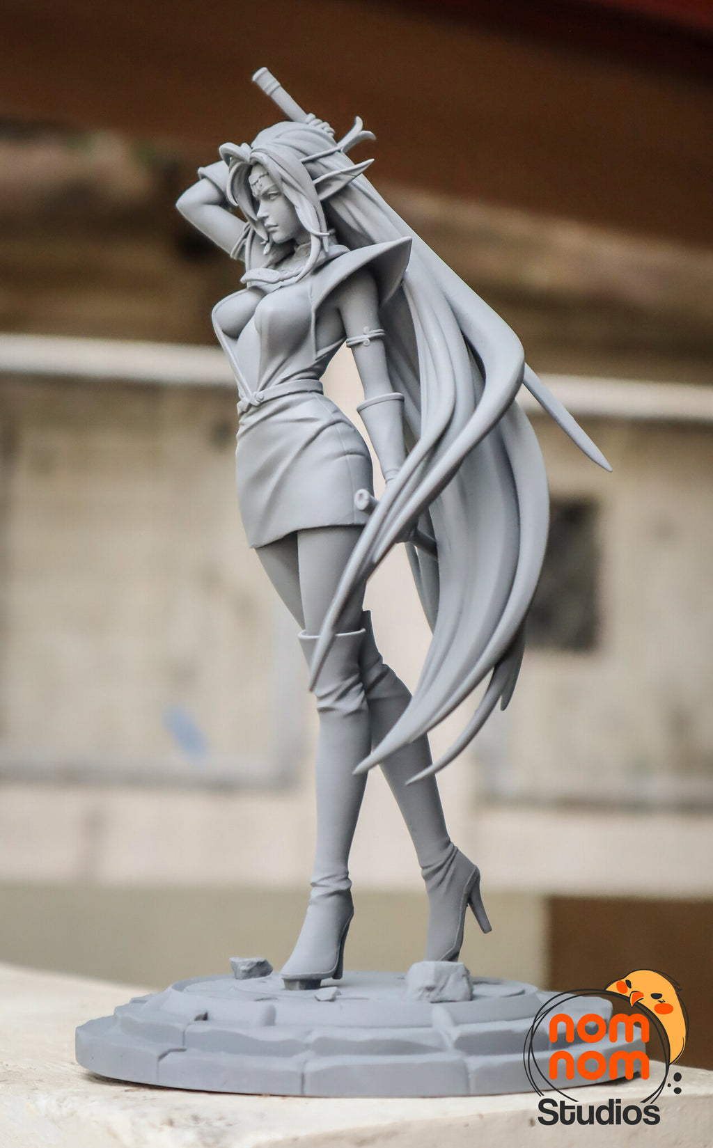Sculptor's photo of an unpainted print: three-quarter view with the raised sword and the hair trailing behind her