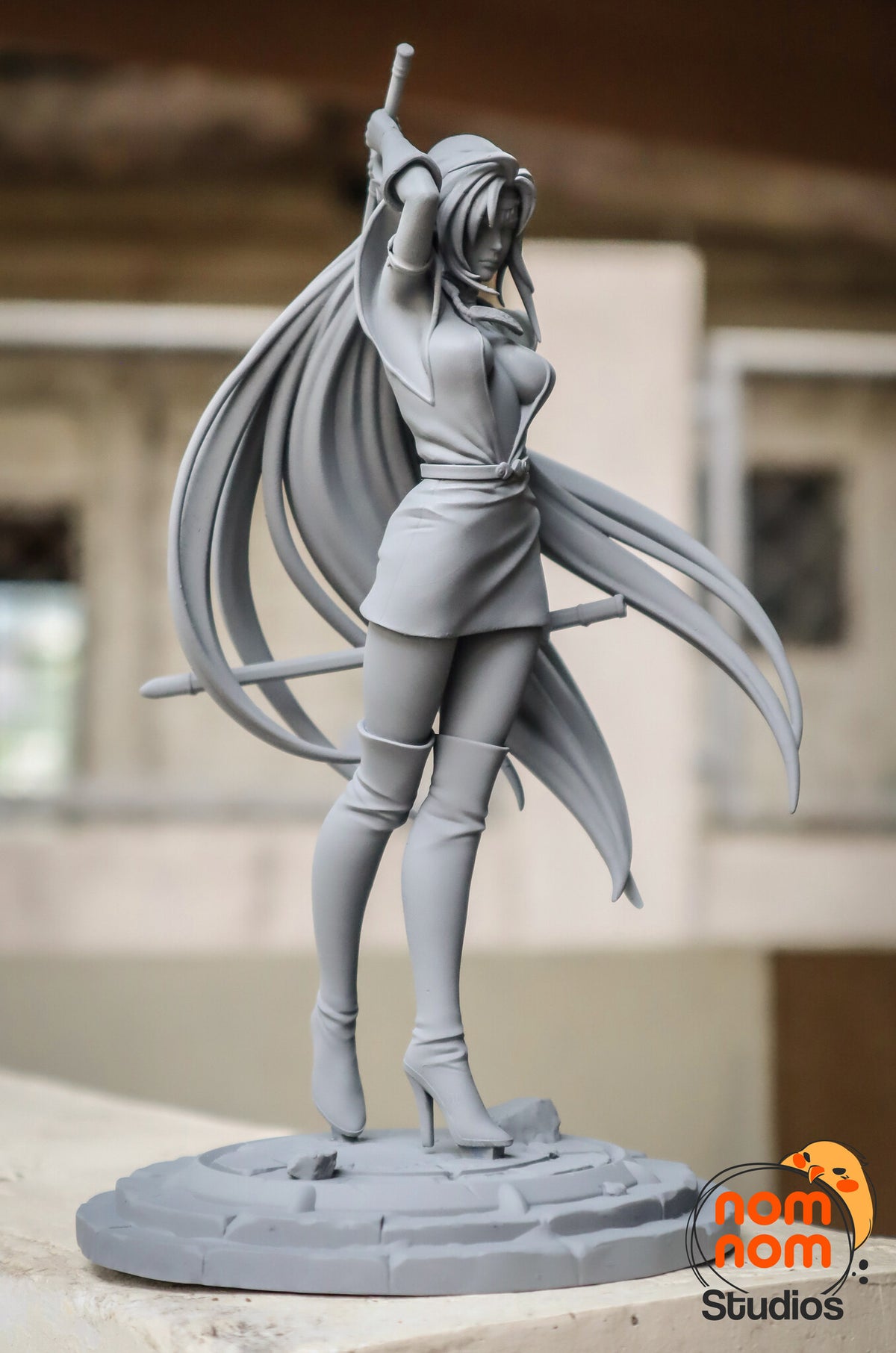 Sculptor's photo of an unpainted print: front three-quarter view from her left, the low sword reaching past her hip