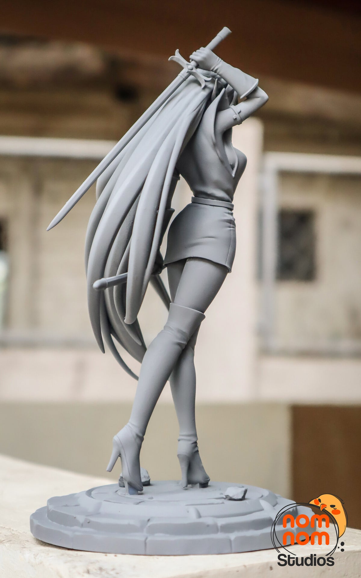 Sculptor's photo of an unpainted print: rear view from her left with the raised sword's blade crossing the hair