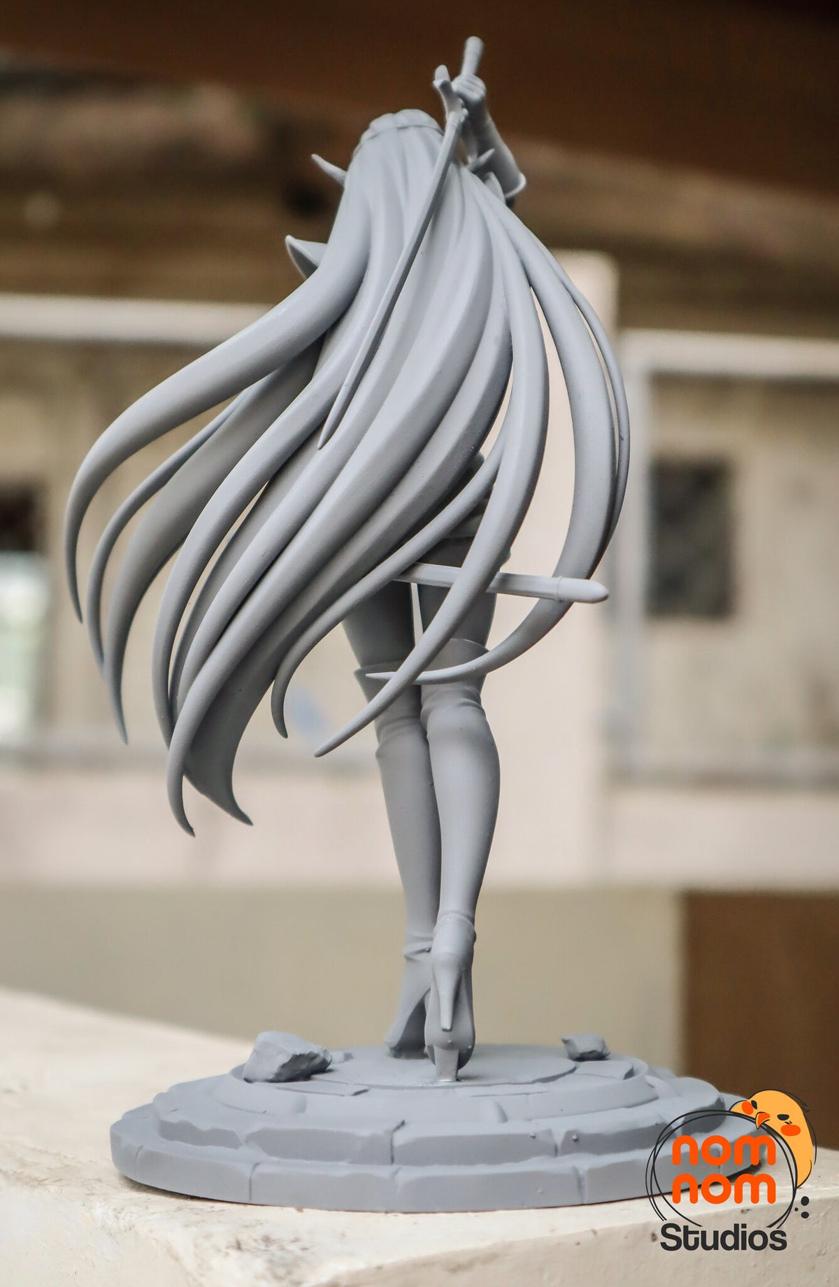 Sculptor's photo of an unpainted print: straight-on back view of the hair, boots and plinth