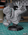 Studio photo of an unpainted gray test print (kit ships unpainted): front three-quarter view of the lunging bust, flame-wrapped fist low and open hand raised high, on the black plinth