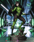 Sculptor's render of the painted design (kit ships unpainted): front three-quarter view of the figure in the green-and-black catsuit, one clawed hand raised and one boot up on the glowing rock, on the round base
