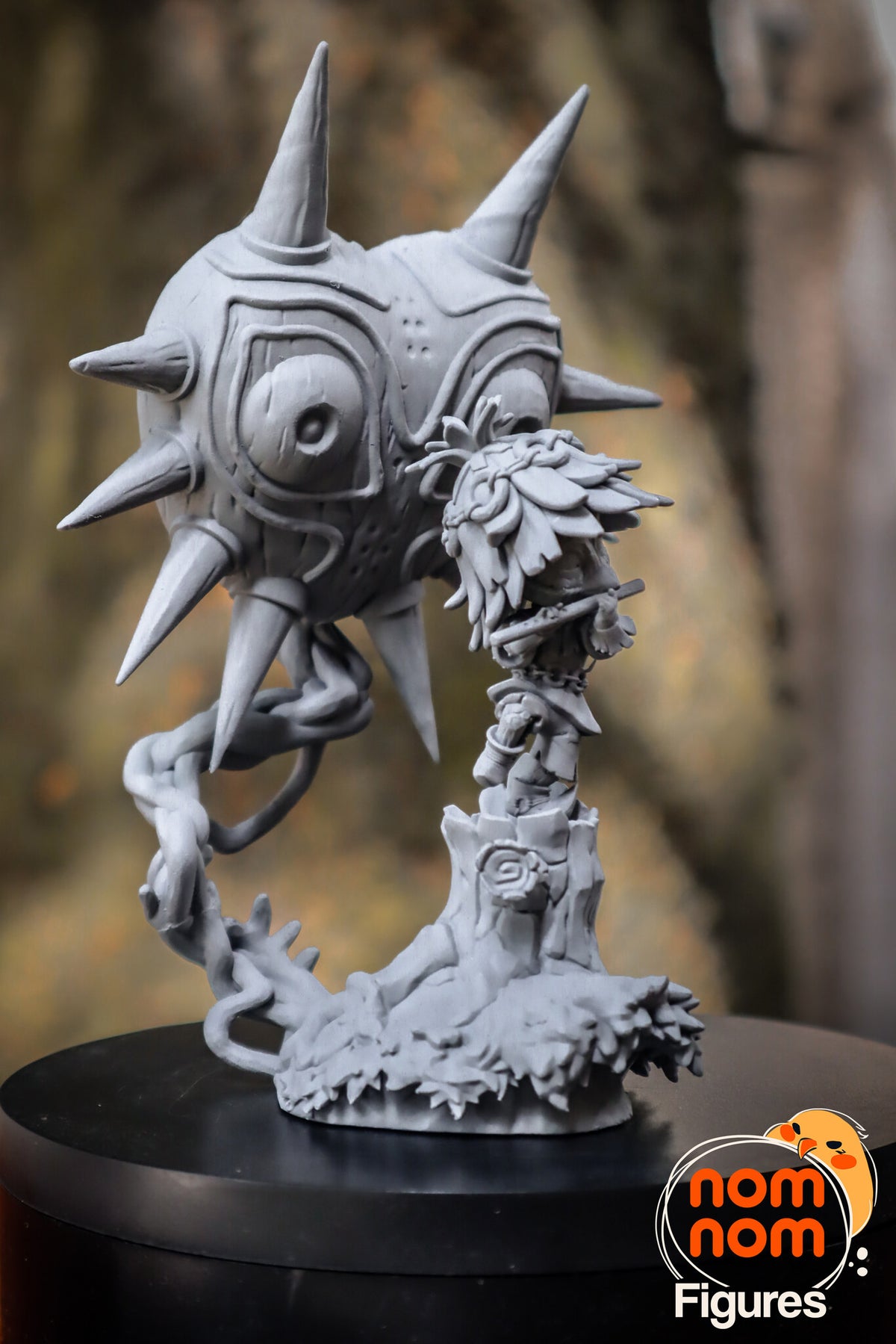 Sculptor's photo of an unpainted print: three-quarter view with the twisted vine sweeping from its thorny root up to the mask