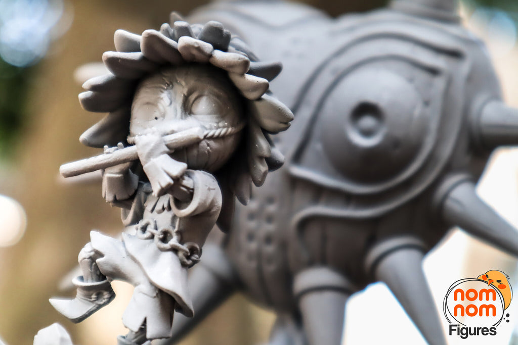 Sculptor's photo of an unpainted print: close-up of the imp's carved wooden face, rope-tied snout and flute