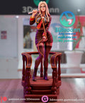 Sculptor's render of the painted design (kit ships unpainted): full-length front view of the blonde figure in glasses and a brown uniform, whip handle at her shoulder, inside the wooden balustrade on the round staircase platform